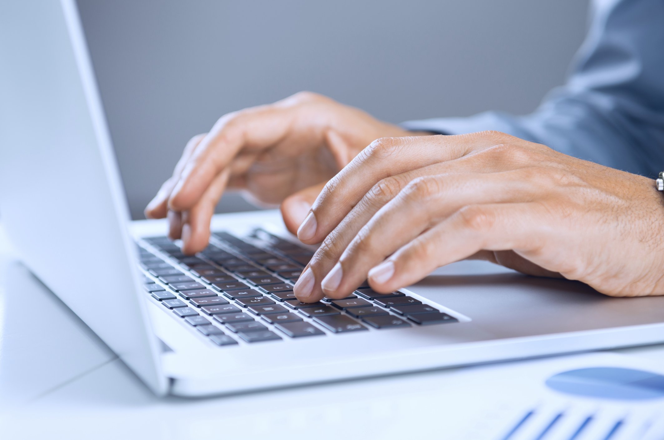 A person typing on a laptop keyboard