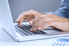 A person typing on a laptop keyboard